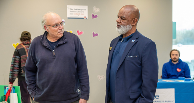 CEO Gregory A. Hill, Sr. speaking with a patron at the Heart of Every Neighborhood event at Glendale Branch.
