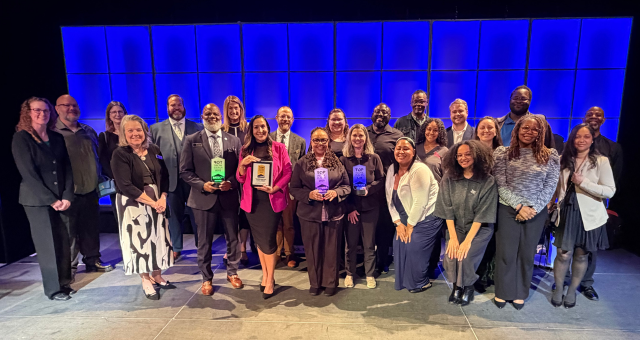 Gregory A. Hill, Sr., CEO, The Indianapolis Public Library poses with a large staff group after the Library is named a 2026 Top Workplace.