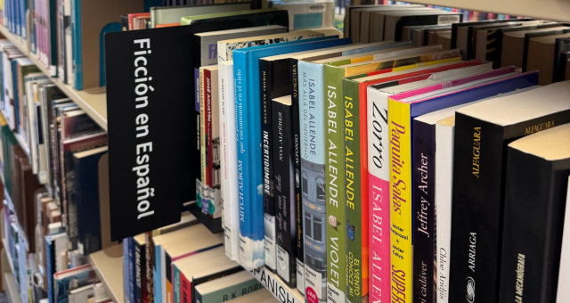 Books on a shelf with a sign that says Ficcion en Espanol.