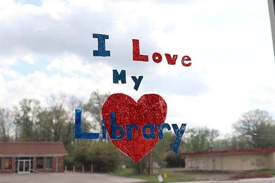 A hand painted “I Love My Library” sign on a window of the East 38th Street Branch.