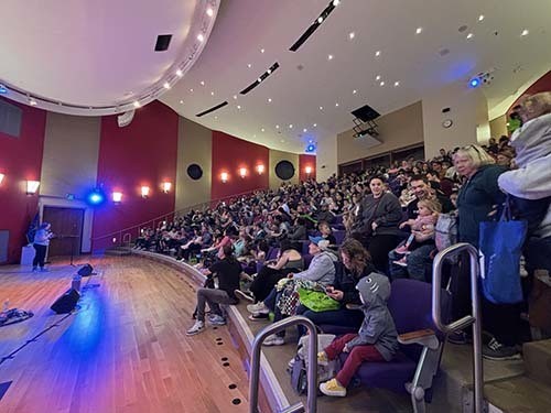 The seats of the auitorium at Central Library are full of children and their caregivers.