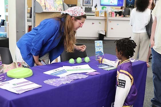 A young patron visiting a table of giveaways.