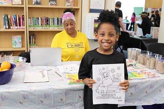 A young patron showing off a coloring sheet.