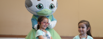 Children take pictures with Katerina Kittycat from Daniel Tiger's Neighborhood at Día del Niño.