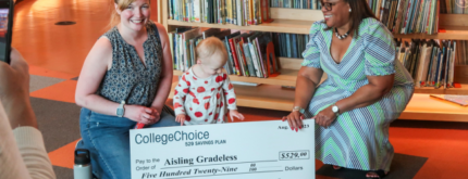 Aisling receives a CollegeChoice 529 check, a grand prize in the IndyPL Summer Reading Program.